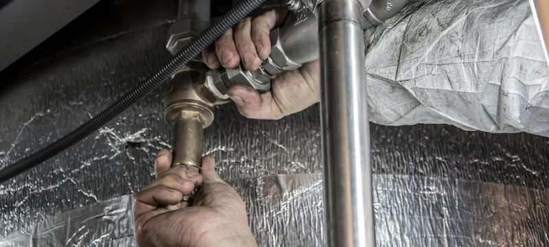 Plumber installing pipe fittings on a job site